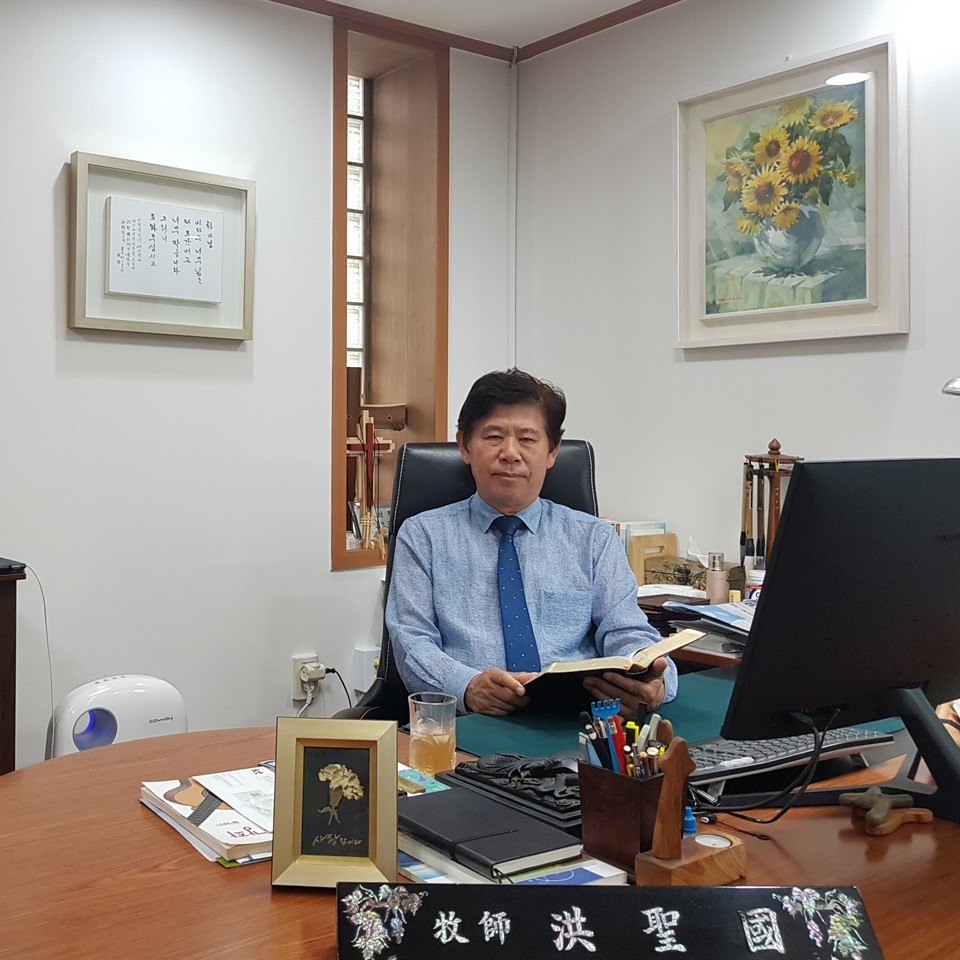 책상에 앉아 성경을 펼쳐 든 홍성국 목사